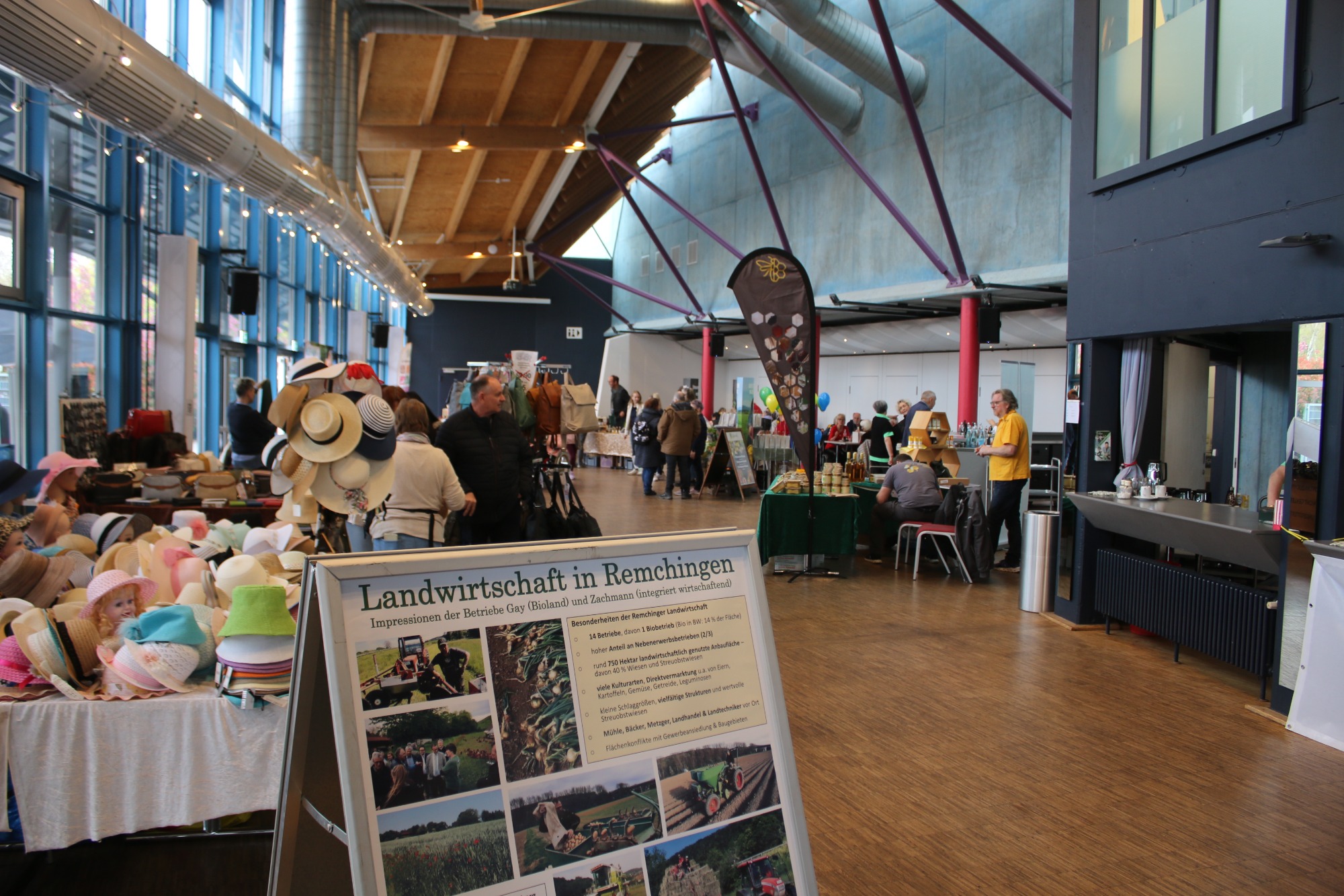 Markthalle mit Ständen, Besuchern und einem großen, offenen Raum für Veranstaltungen.