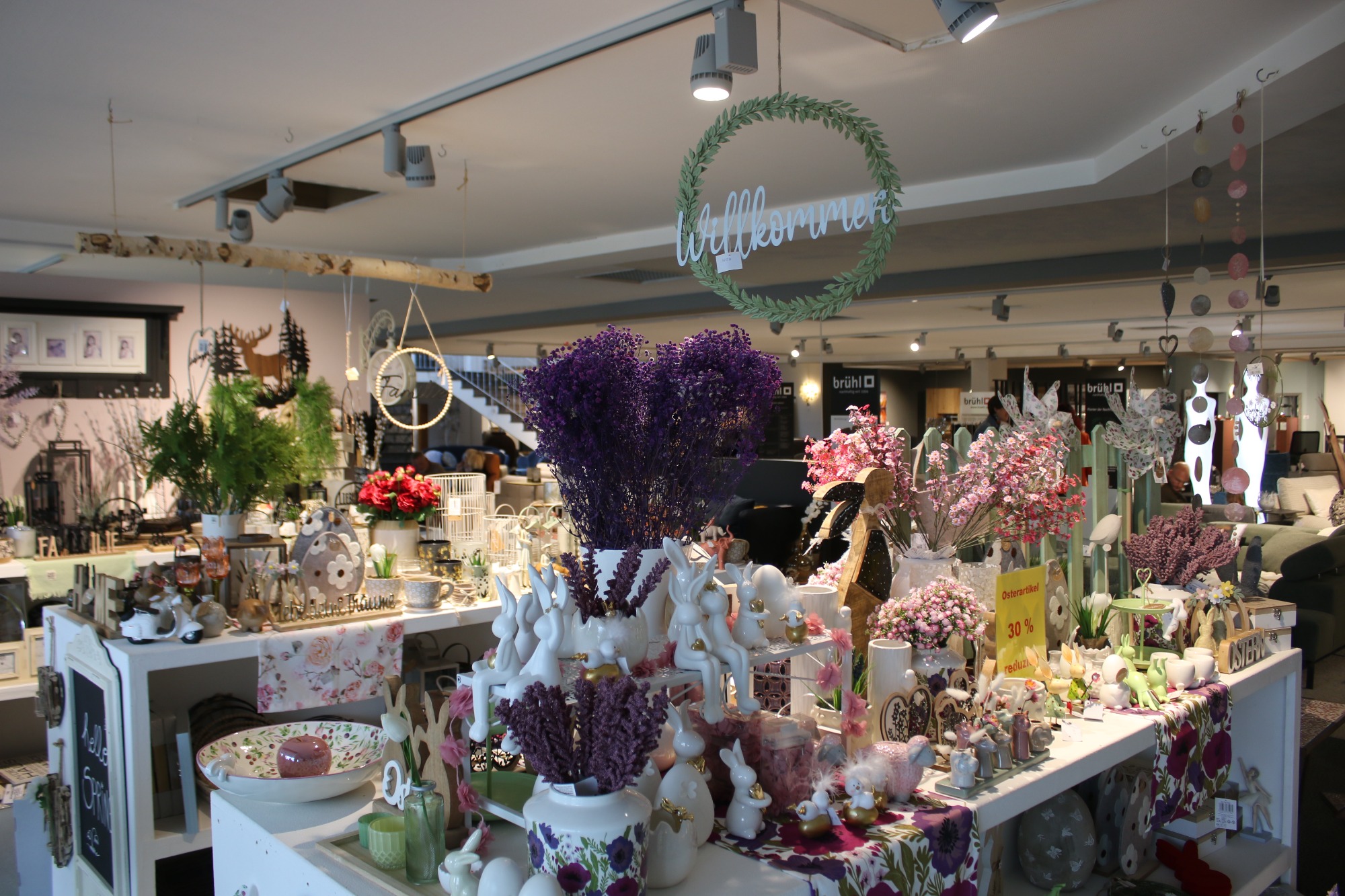 Blumengeschäft mit bunten Pflanzen und dekorativen Artikeln in einem hellen Raum.