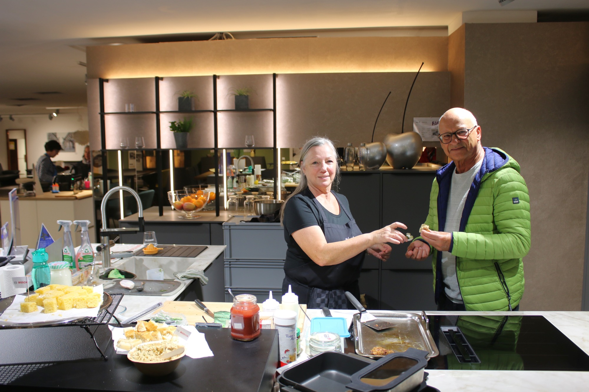 Eine Frau und ein Mann tauschen etwas in einer modernen Küche aus.