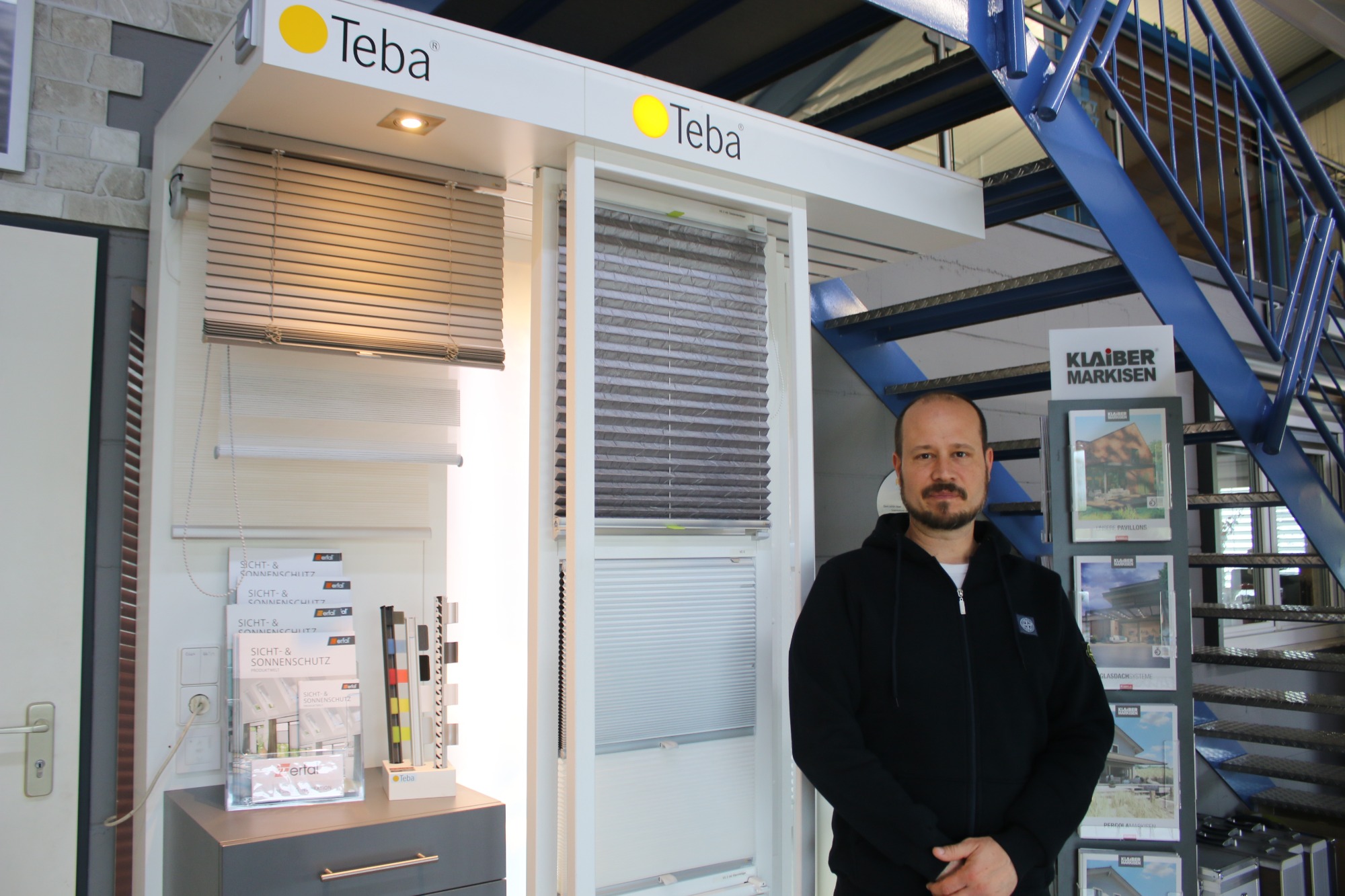 Mann steht neben einem Fensterladen-Muster von der Marke Teba.